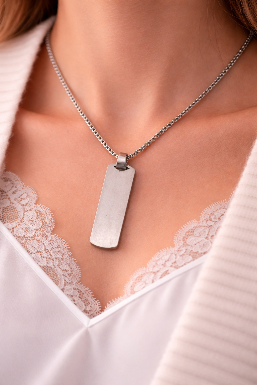 Silberne Halskette mit rechteckigem Edelstahl-Anhänger an Damenhals