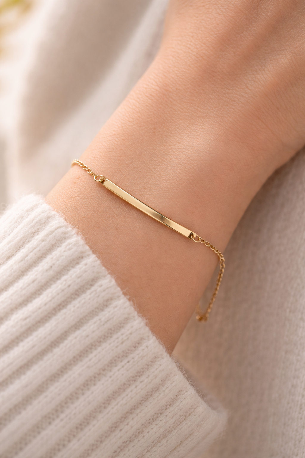 Goldenes Armband mit rechteckigem Edelstahl-Element am Handgelenk