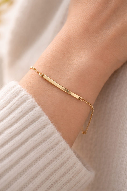 Goldenes Armband mit rechteckigem Edelstahl-Element am Handgelenk