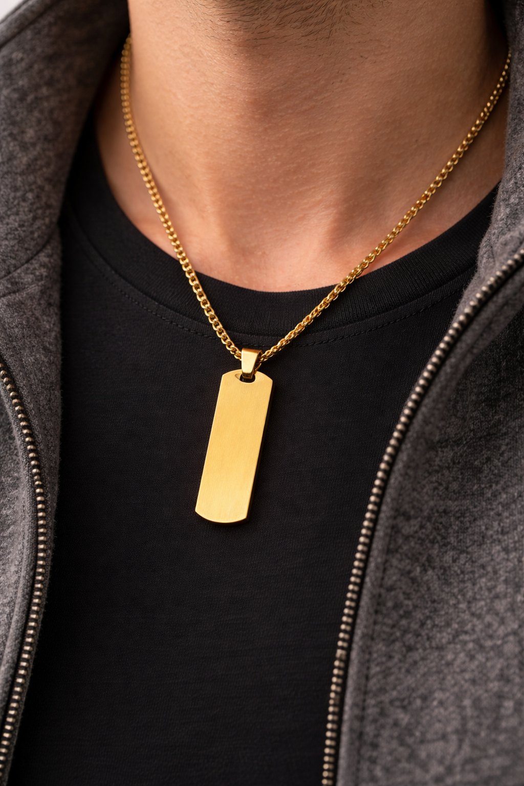 Goldene Halskette mit rechteckigem Edelstahl-Anhänger an Herrenhals