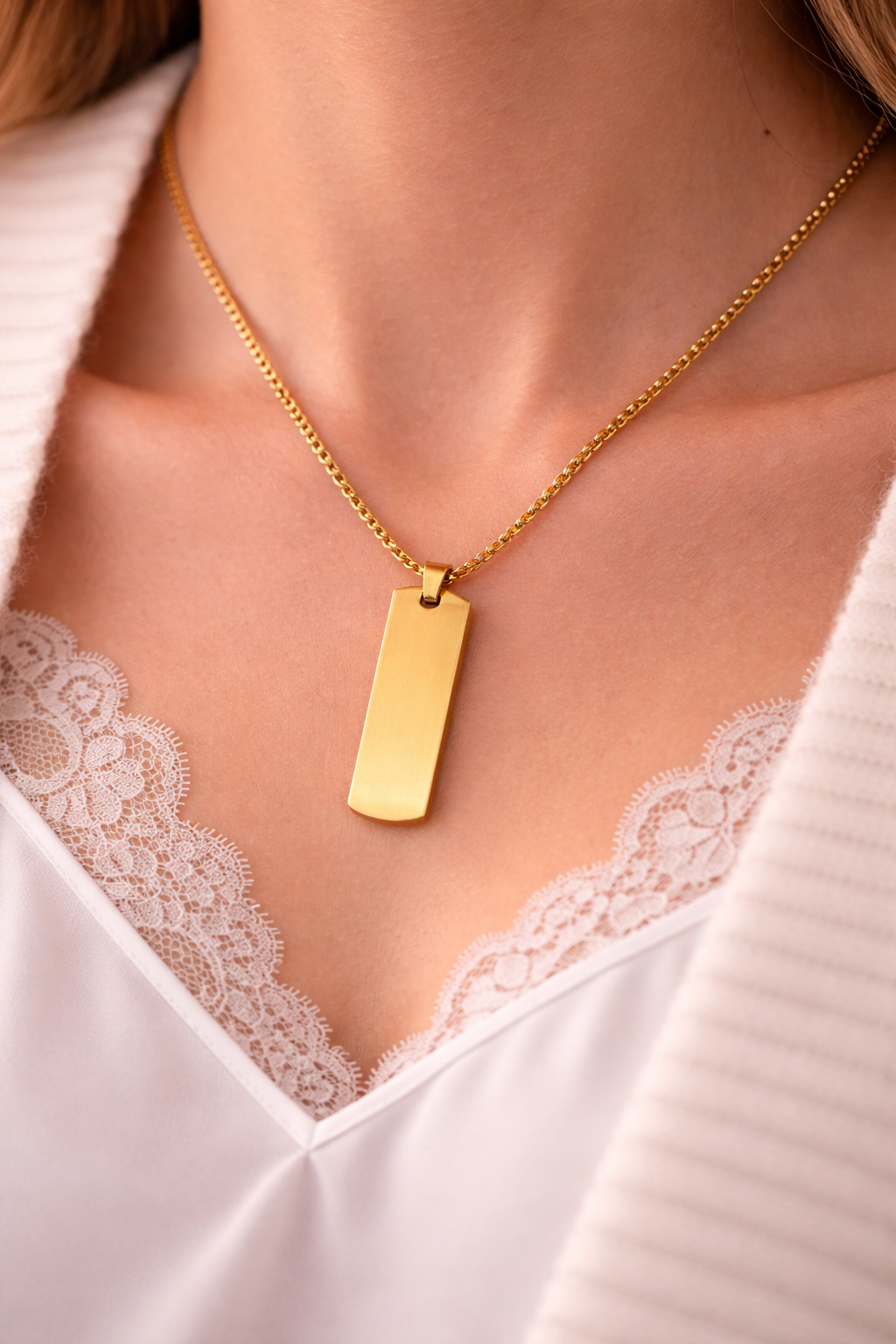 Goldene Halskette mit rechteckigem Edelstahl-Anhänger an Damenhals