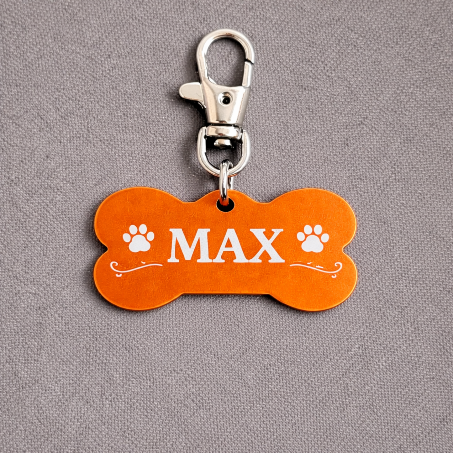 Personalisierte Hundemarke aus Aluminium in Knochenform mit Lasergravur, Name MAX, Pfotenmotiv, orange, hochwertiger Hundeanhänger